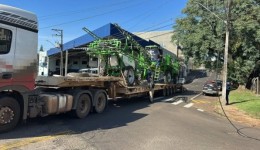 Caminhão que transportava máquina agrícola enrosca em fios e interdita cruzamento